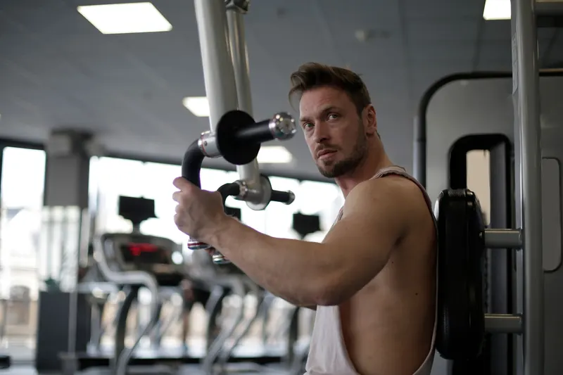 Focused man working out in a gym, showcasing biceps and determination