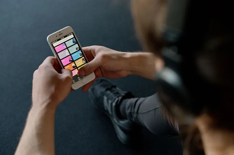 Close-up of a person listening to music on a smartphone while at the gym, focusing on a streaming playlist app